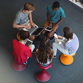 Students use laptops and tablets together in a library