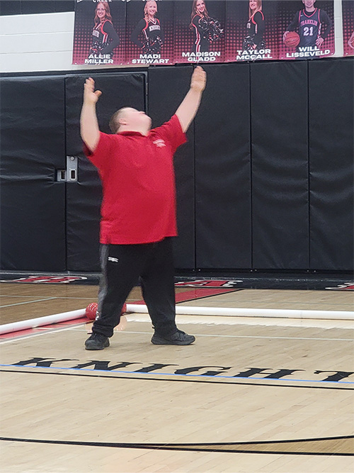 Student in red playing bocce ball